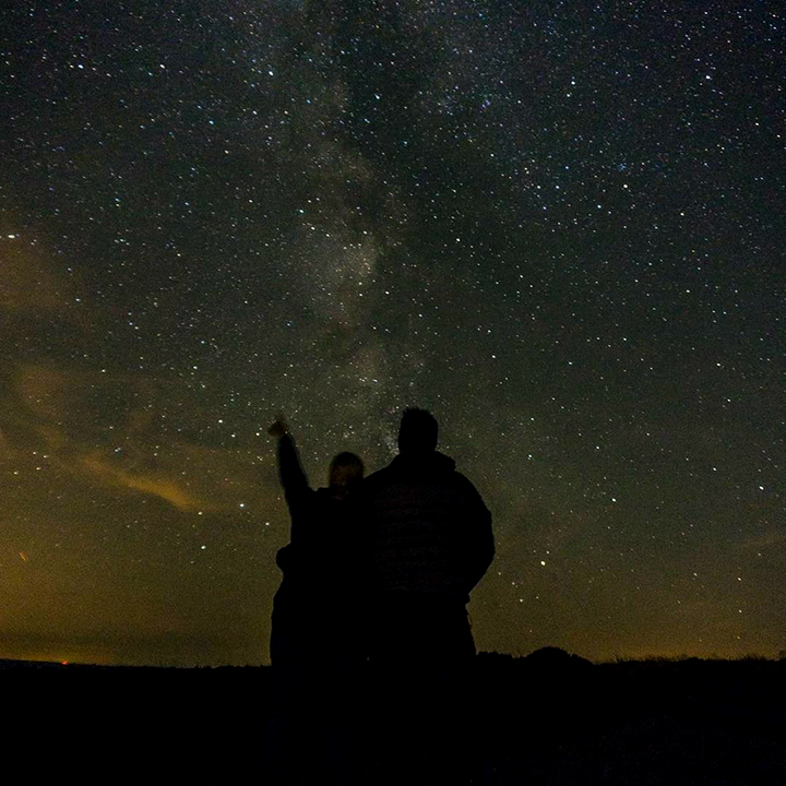 Photo of people looking up at a starry sky